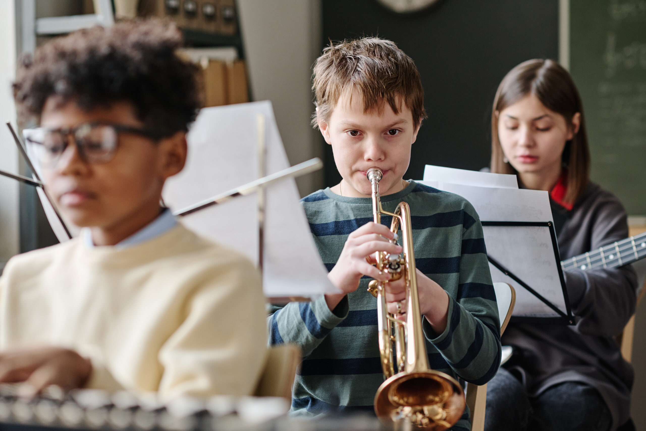 Kinderen bespelen een muziekinstrument. Jongen met trompet. 